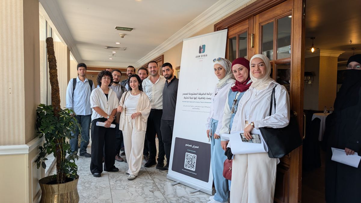 OSM Syria community members beside the community banner at the Damascus meetup, September 2026